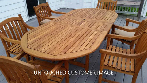 A polished wooden outdoor dining table with eight matching chairs on a deck, showcasing a natural finish and elegant design.