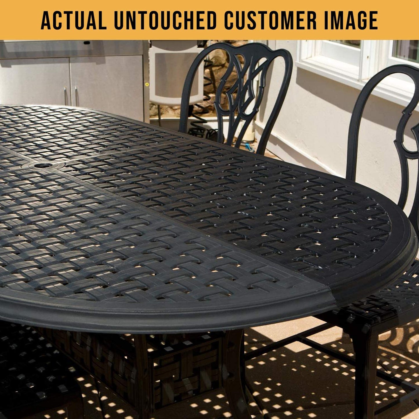 A close-up view of a black, woven outdoor dining table and matching chairs, showcasing intricate designs in sunlight.