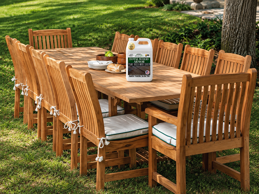 Total Wood Sealer by Seal-It Green displayed on a teak outdoor dining table surrounded by wooden chairs in a sunny garden.