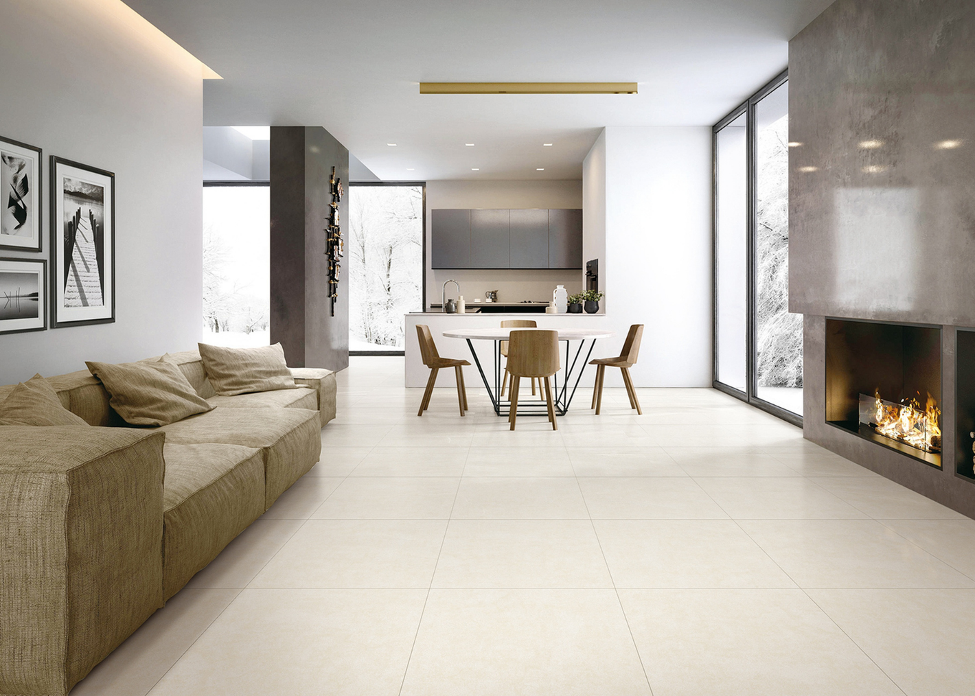 A modern, stylish living area featuring a beige sectional sofa, dining table, wooden chairs, and a sleek fireplace with a snowy view.