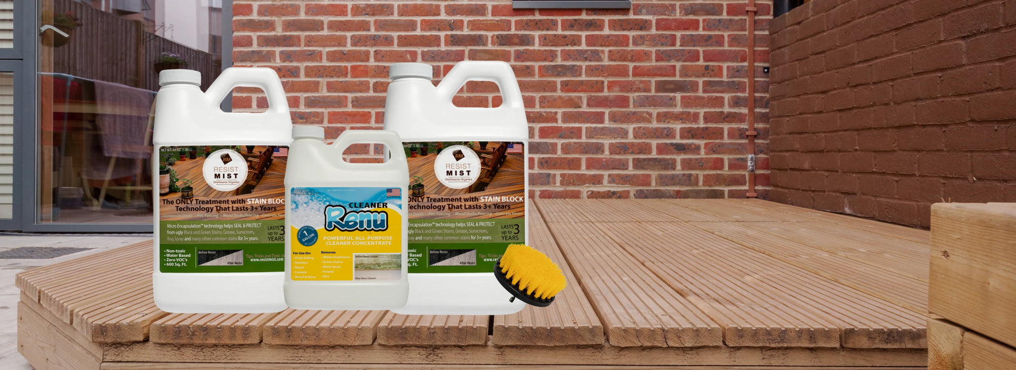 Three containers of cleaning solutions, including Resist Mist and Renu, with a scrub brush, displayed on wooden decking against a brick wall.