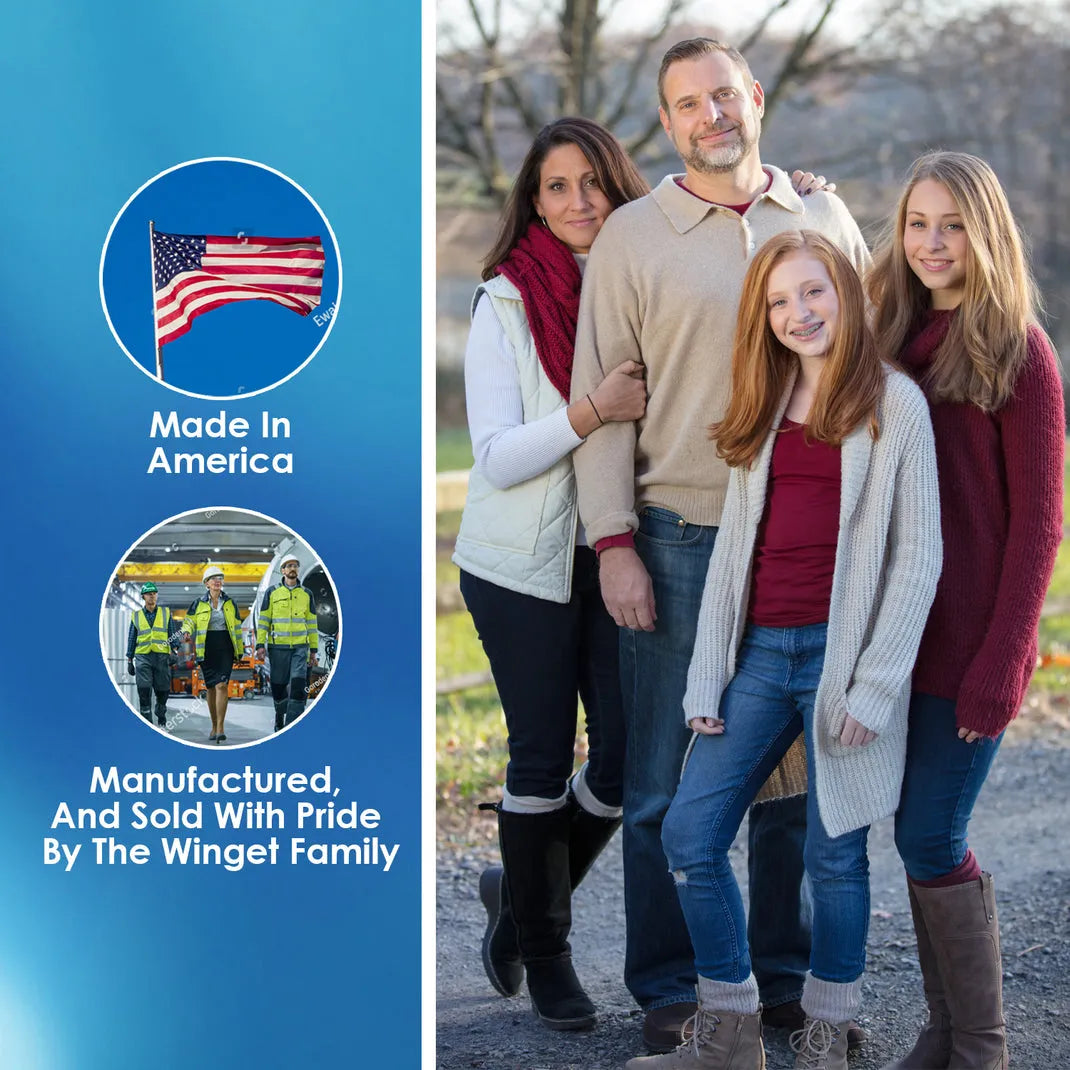A family of four stands together outdoors, showcasing warm autumn attire, with a blurred background of trees and a clear sky.